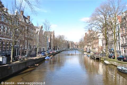 Amsterdam canal with brick houses, bicycles and moored boats