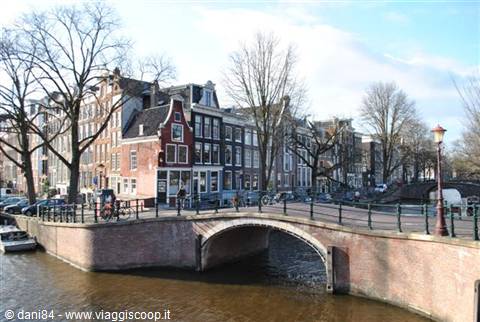 Brick bridge over Amsterdam canal among historic houses and bicycles