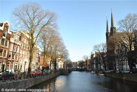 Amsterdam canal with brick houses, twin-spired church and bare trees