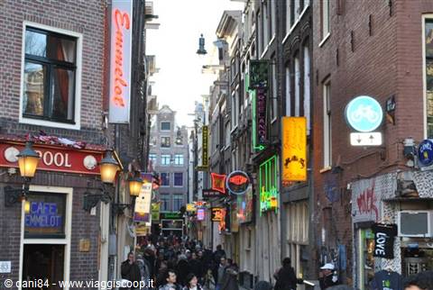 Busy street with neon signs among brick buildings in Amsterdam