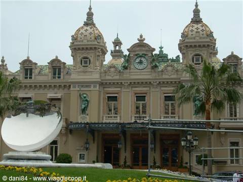 Ornate facade of Monte Carlo Casino with domes, clock and palm trees
