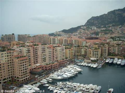 Yachts moored at Fontvieille harbour in Monaco among ochre buildings