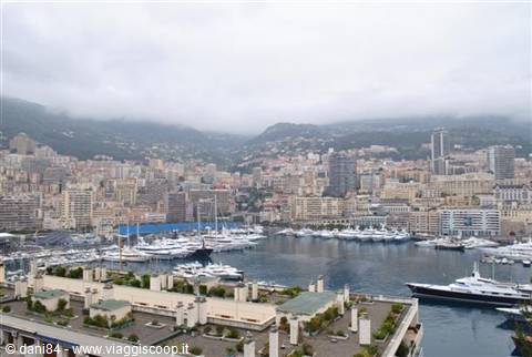 Yachts moored at Monte Carlo harbor under a cloudy sky