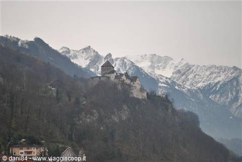 Vaduz Castle on a wooded hill with snowy Alps behind