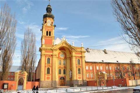 Wilten Basilica in Innsbruck, yellow and pink facade, snow and blue sky
