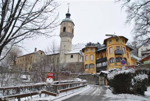 Church with green-domed tower above snow-covered houses
