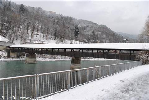 snow-covered wooden covered bridge crossing the Aare river in Interlaken