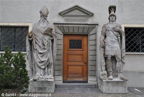 Stone statues of a bishop and a knight flanking the wooden church door