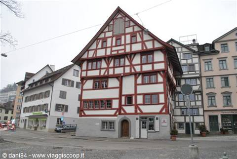 Red and white half-timbered house on a square, grey sky