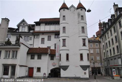 White medieval tower with red roofs among historic town buildings