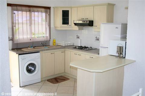 Equipped kitchen with washing machine, sink and fridge under the window