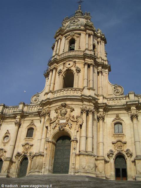 Baroque facade of San Giorgio Cathedral in Modica, pale stone under blue sky