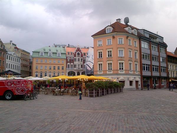 Dome Square in Riga, yellow cafe umbrellas beside colorful historic houses