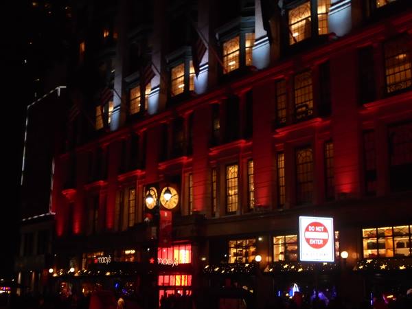 Macy's facade at Herald Square lit up in red at night