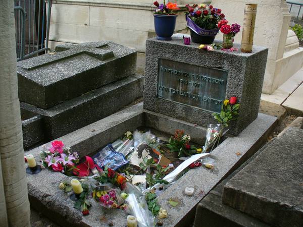 Jim Morrison's grave at Père-Lachaise cemetery, covered with flowers and candles