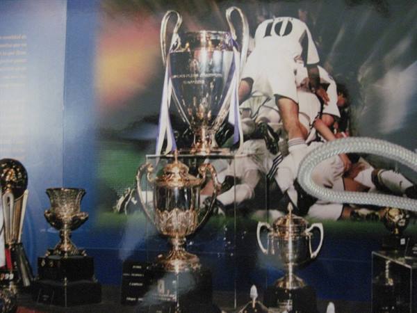 Silver football trophies behind glass, Champions League cup in the center