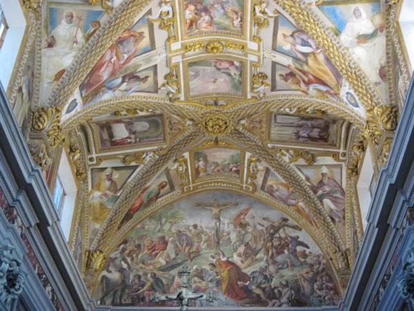 Frescoed vault with biblical scenes and golden stuccoes in a baroque church