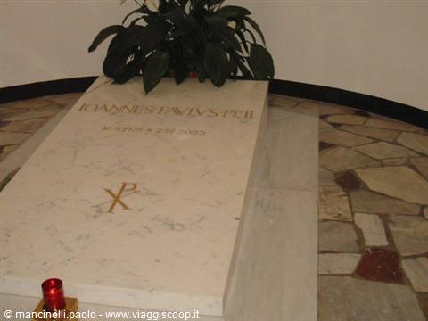 Marble slab over Pope John Paul II's tomb with a lit red candle
