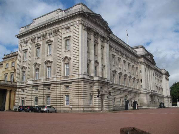 Neoclassical facade of Buckingham Palace in London, pale stone under cloudy sky