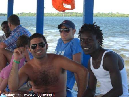 Smiling tourists and locals aboard a blue boat on the water