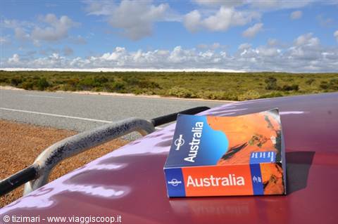 Lonely Planet Australia guidebook on car hood by the road