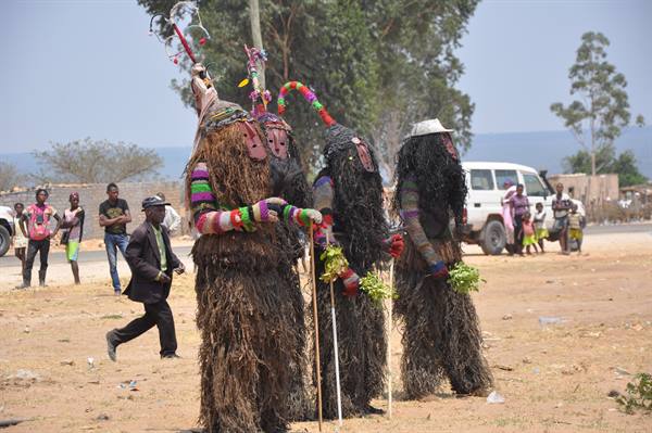 Nyau masked dancers in raffia and fiber costumes performing traditional ceremony