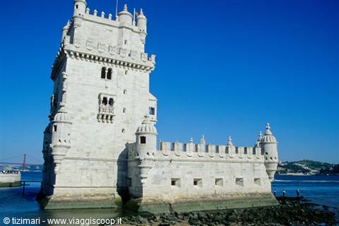 Belém Tower in limestone standing on the Tagus waters, blue sky