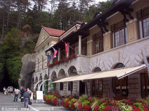 Stone building with arches, awnings and flowers at Postojna Cave entrance
