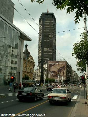 Cars on the street with the Beograđanka skyscraper among buildings
