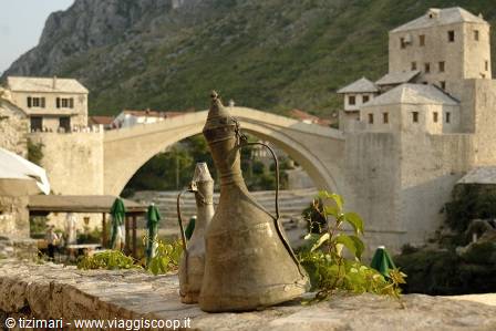Copper pitchers in the foreground with Mostar's Old Bridge behind