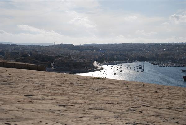 Limestone ramparts with boats moored in the Grand Harbour below Valletta