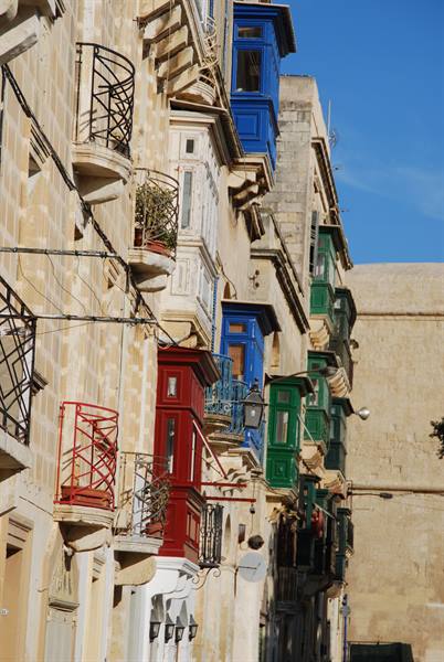 Colorful closed wooden balconies on limestone facades, Valletta