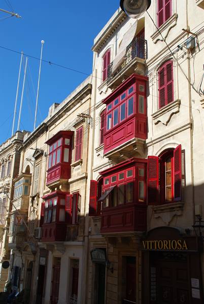 Limestone facade with traditional red wooden enclosed balconies, Vittoriosa