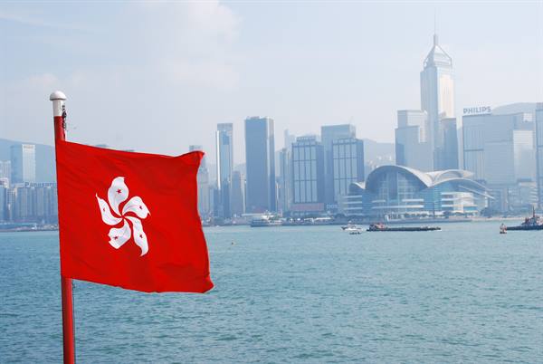 Hong Kong red flag waving over the harbour in front of skyscrapers