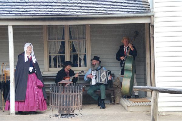 Musicisti in costume d'epoca suonano fisarmonica, chitarra e contrabbasso a Sovereign Hill, Ballarat