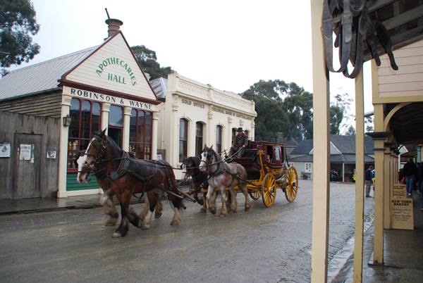 Cavalli trainano una carrozza rossa e gialla vicino alla Sovereign Hill di Ballarat