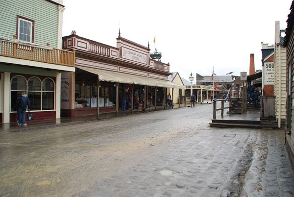 Via sterrata bagnata di Sovereign Hill, Ballarat, case lignee d'epoca sotto cielo grigio