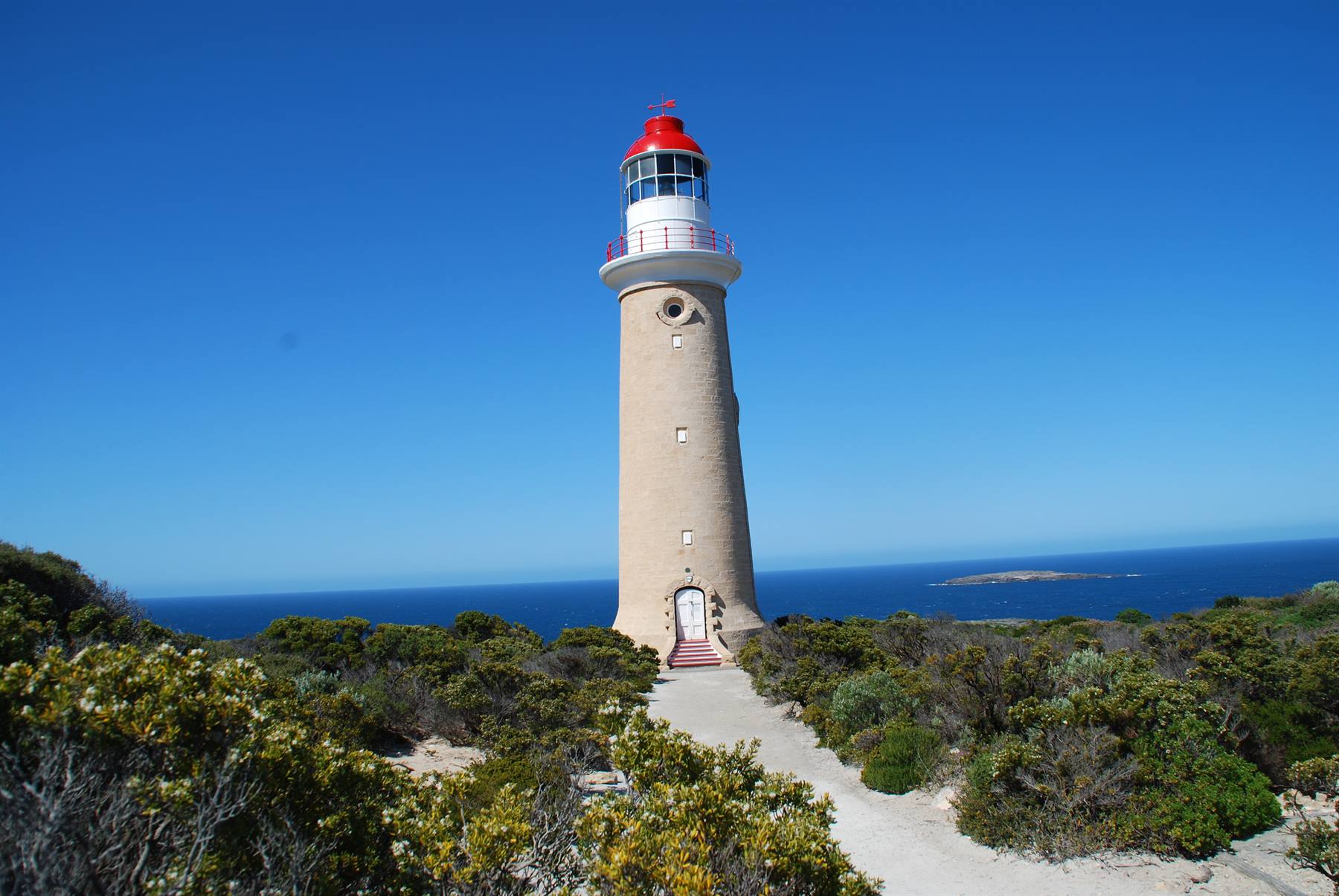 Faro di pietra con lanterna rossa su Cape du Couedic, Kangaroo Island, cielo azzurro