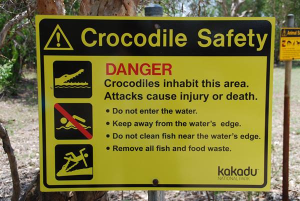 Cartello giallo "Crocodile Safety" a Kakadu National Park tra gli alberi