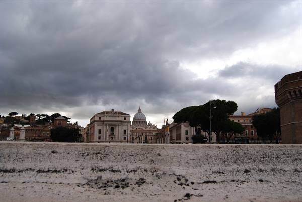 St. Peter's dome under dark clouds, marble foreground, Rome