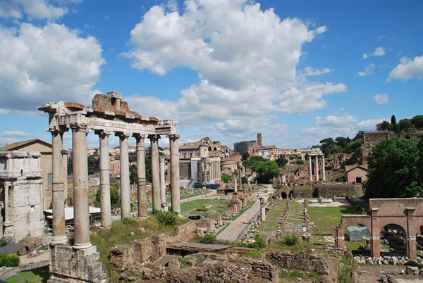 Columns of the Temple of Saturn at the Roman Forum under white clouds