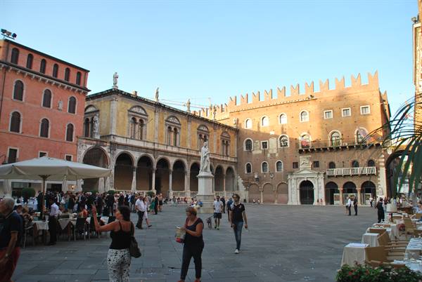Piazza dei Signori in Verona, tourists stroll around Dante's statue