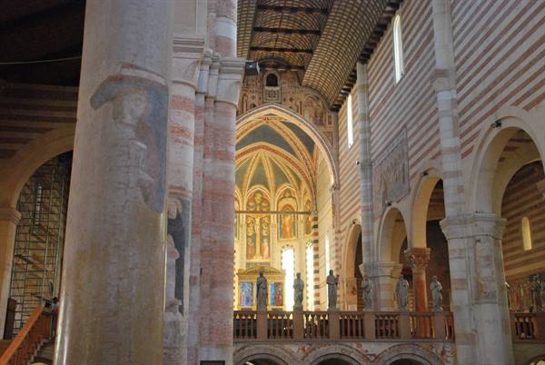 Inside San Zeno Basilica in Verona, stone columns, frescoes and statues