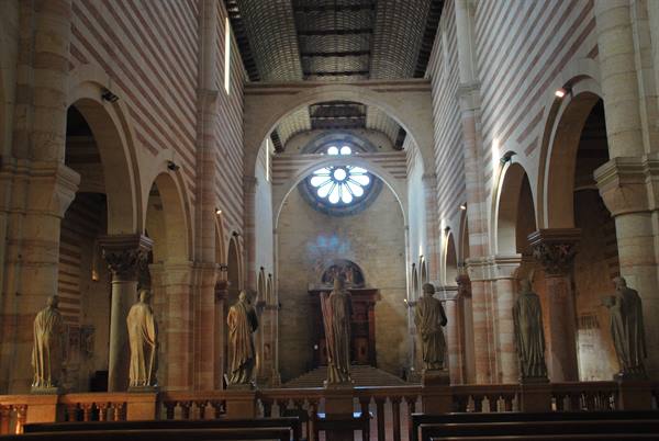 Prophet statues inside San Zeno Basilica in Verona, illuminated rose window