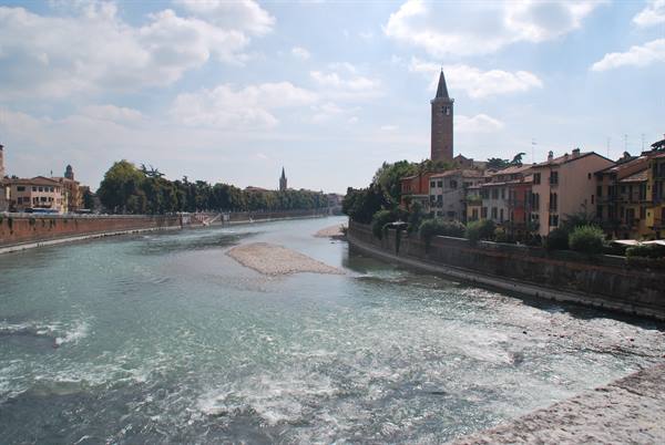 The Adige river in Verona with Sant'Anastasia's brick tower among colored houses