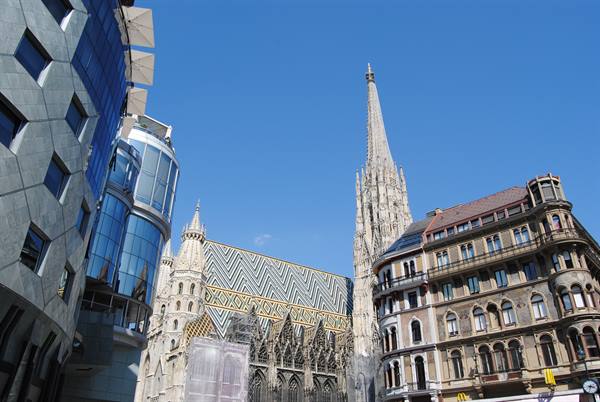 The colorful tiled roof of St. Stephen's Cathedral in Vienna among modern and historic buildings