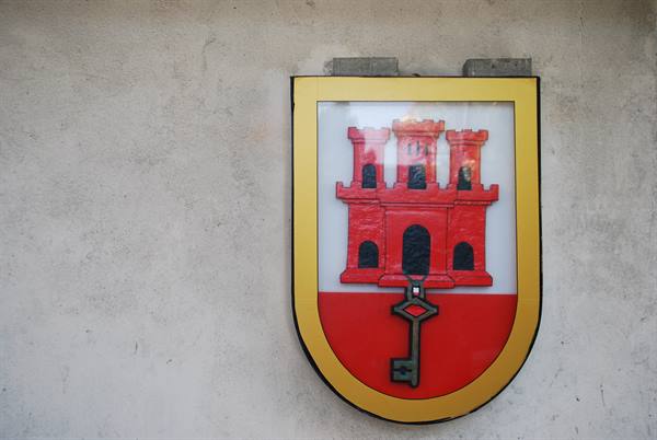 Genoa coat of arms with red castle and key on gray wall