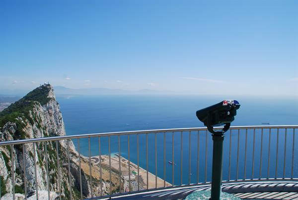 Viewing telescope on railed terrace overlooking Gibraltar Rock and the blue sea