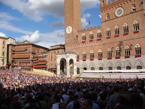 Crowd in Siena's Piazza del Campo beneath Torre del Mangia during the Palio