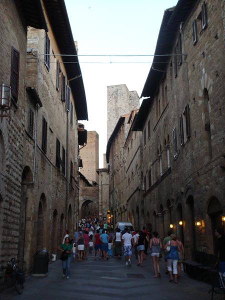 Crowded stone street lined with medieval towers, San Gimignano